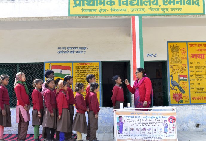 School children line up to get their dose of albendazole on National Deworming Day.