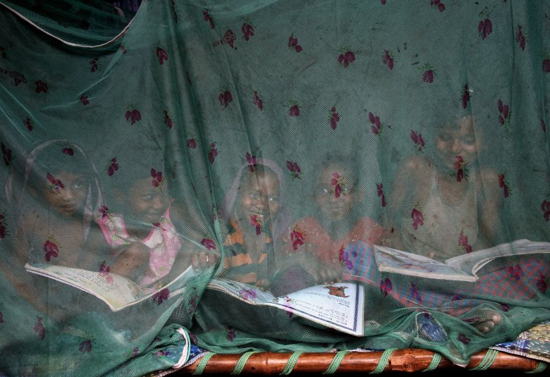 Credit: Sudipto Das Caption: Fighting with Malaria. Children enjoy a summer afternoon sitting inside a mosquito net recently distributed by local health department at a plasmodium falciparum malaria prone area in a remote village in Birbhum, India to prevent mosquito borne diseases. Living far below poverty level these tribal families rarely manage to purchase mosquito net/ repellent resulting to a high death toll in the areas.