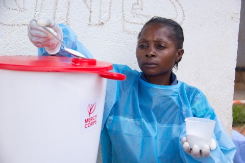Beni, North Kivu, DR Congo. Kavira Safari Esperance, a hygienist at the Malepe Health Center, has attended the Mercy Corps promoted hygiene awareness outreaches against Ebola. She is using chlorine to disinfect the water used to wash hands. © Mercy Corps Beni, North Kivu, DR Congo. Kavira Safari Esperance, a hygienist at the Malepe Health Center, has attended the Mercy Corps promoted hygiene awareness outreaches against Ebola. She is using chlorine to disinfect the water used to wash hands. © Mercy Corps